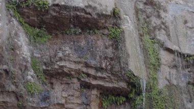 Dar su akıntıları kayalık dağdan aşağı düşüyor.