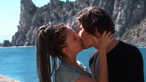 Jovem casal bonito beijando em um fundo de uma baía do mar — Vídeo de Stock
