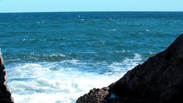 Strahlend blaue Meereswellen krachen gegen Felsen - eine Landschaft — Stockvideo