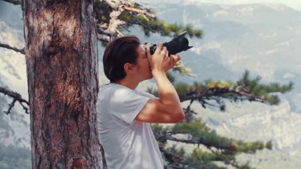 Junger Mann fotografiert die Natur mit der Kamera — Stockvideo