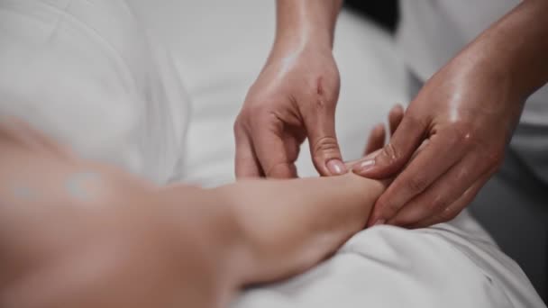 Donna che riceve un massaggio massaggiandosi la mano con un olio — Video Stock