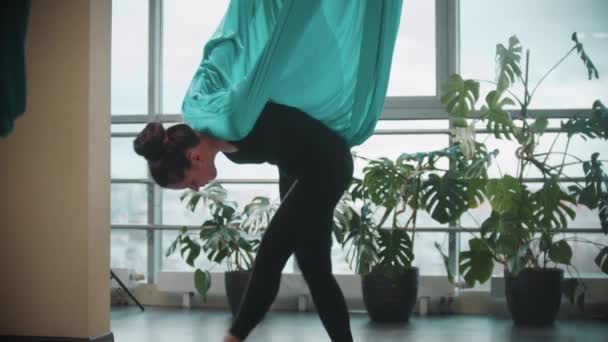 Yoga aérien en studio - femme adulte en vêtements noirs s'exerçant à l'aide de l'hamac — Video
