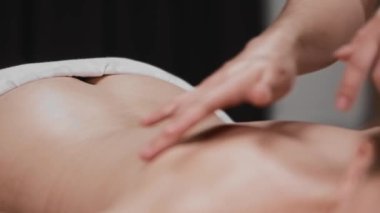 Masaj seansı - masajcı müşterisinin tenini hafifçe parmaklarıyla okşuyor