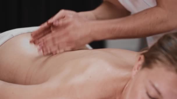 Massage-Sitzung - Masseurin klopft mit dem Rand ihrer Handflächen auf den Rücken — Stockvideo