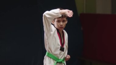 Küçük bir çocuk dövüş sanatları yapıyor.
