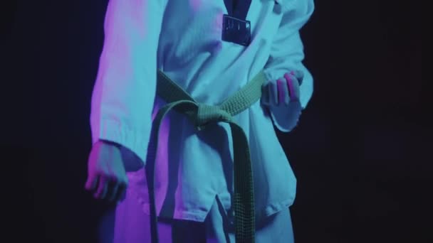 Un ragazzino che fa taekwondo nell'illuminazione al neon - mostrando mosse con le mani — Video Stock
