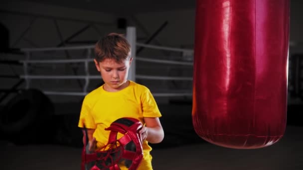 Un niño pequeño haciendo boxeo - se pone el casco protector — Vídeos de Stock