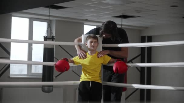 Chlap trenér masíruje ramena svého studenta boxu na prstenu — Stock video