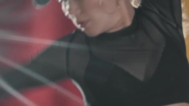 Siyah şeffaf takım elbiseli dövmeli kadın dansçı sarı stüdyoda dans ediyor.