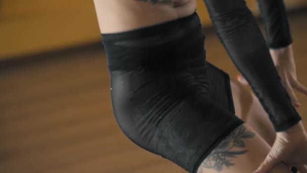Bailarina mujer tatuada en traje translúcido negro realizando una danza sexy en estudio amarillo — Vídeos de Stock