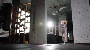 Pilates yapan genç bir kadın. Yoga minderine koşup egzersiz yapıyor.