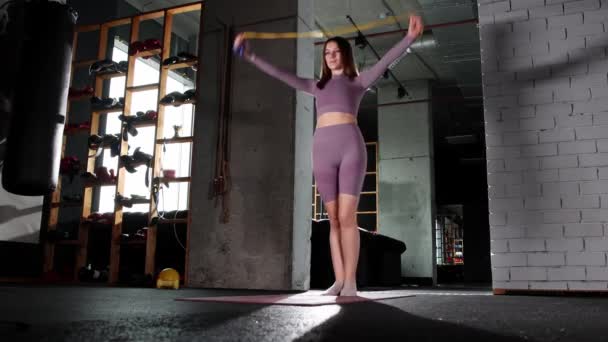Νεαρή γυναίκα που δουλεύει με ένα σχοινάκι στο γυμναστήριο — Αρχείο Βίντεο