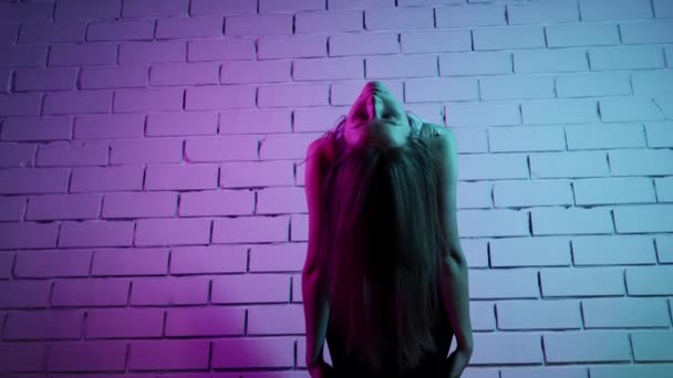 Junge Frau macht Pilates-Übungen - wärmt ihren Körper im Neonlicht auf — Stockvideo