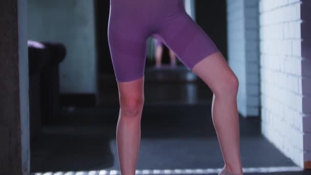 Mujer joven en traje deportivo púrpura jugando con una cuerda de salto — Vídeos de Stock