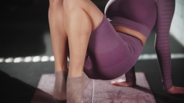 Mujer bonita joven haciendo ejercicio en el gimnasio - calienta sus dedos de los pies en la esterilla de yoga — Vídeos de Stock