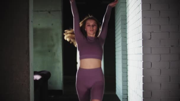 Mujer joven corriendo en el gimnasio y realizando ejercicios acrobáticos — Vídeos de Stock