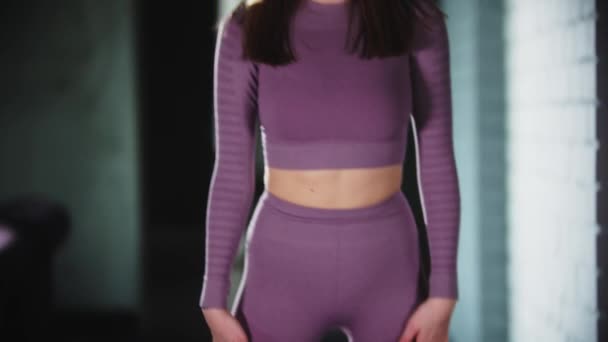 Mujer joven en traje deportivo púrpura haciendo fitness - calentando — Vídeos de Stock