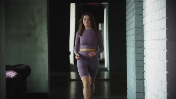 Mladá žena kráčí vpřed v tělocvičně a provádění akrobatických cvičení — Stock video