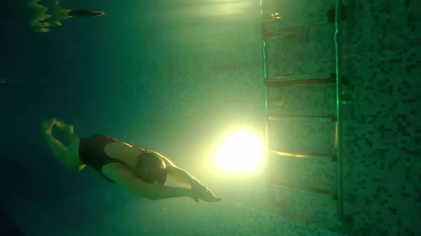Młoda kobieta w czerwonym stroju kąpielowym w basenie pod wodą — Wideo stockowe