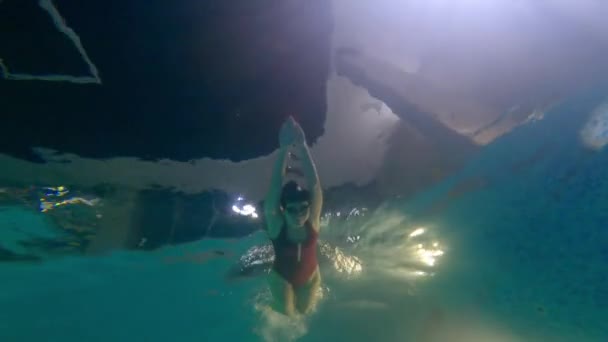 Wanita muda berbaju renang merah berenang di kolam renang — Stok Video