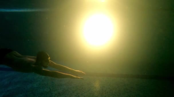 Jovem barbudo nadando debaixo d 'água perto do fundo da piscina — Vídeo de Stock