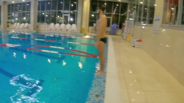 Homem barbudo jovem na piscina de treinamento interior mergulho na água e natação subaquática — Vídeo de Stock