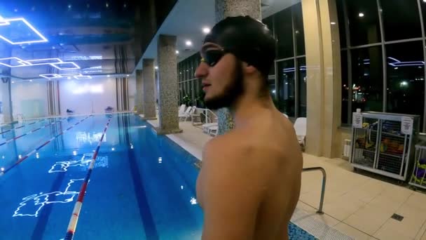 Un hombre en una piscina bucear en el agua y nadar — Vídeo de stock