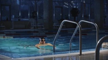 Yüzme sporları - genç sakallı adam suya atlamak için havuzda merdiven kullanıyor.