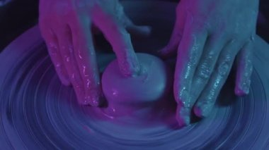 Çömlek atölyesi - kadın elleri kilde bir ara veriyor - neon ışıklandırma