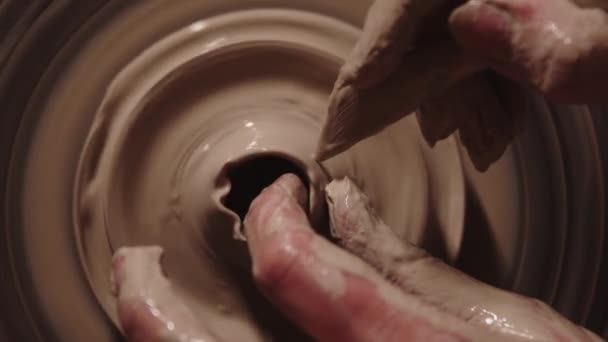 Pottery workshop - wet female hands working with the clay - cutting off the top part — Stockvideo