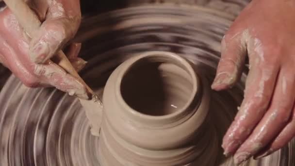 Atelier de ceramică - mâini umede de sex feminin care modelează argila de pe roată folosind un instrument — Videoclip de stoc
