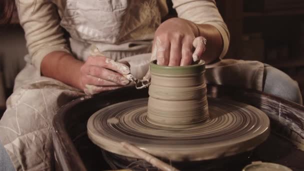 Pottery workshop - female hands fixing the clay shape using a tool on the sides — Stock Video