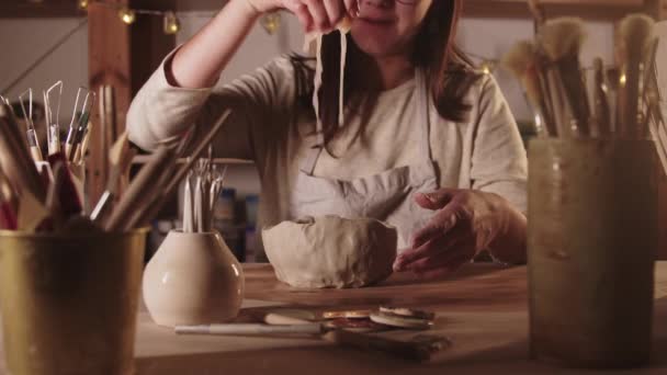 Oficina de cerâmica - jovem mulher molhando o pedaço de barro na mesa e joga-o no ar — Vídeo de Stock