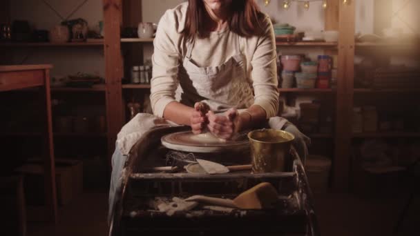 Young woman potter wetting her hands and starts forming the clay with her hands — Vídeo de Stock