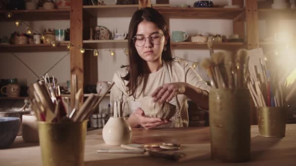 Mujer joven alfarera formando un tazón de arcilla blanda con sus manos en el estudio de arte — Vídeos de Stock