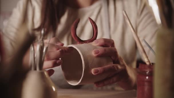 若いです女性陶芸家チェックザカバーのデザイン上のセラミックマグカップとともに彼女の指 — ストック動画