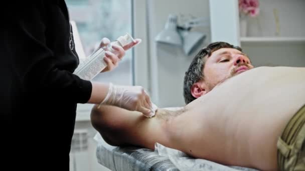 The epilation master disinfects the male armpit — Video Stock