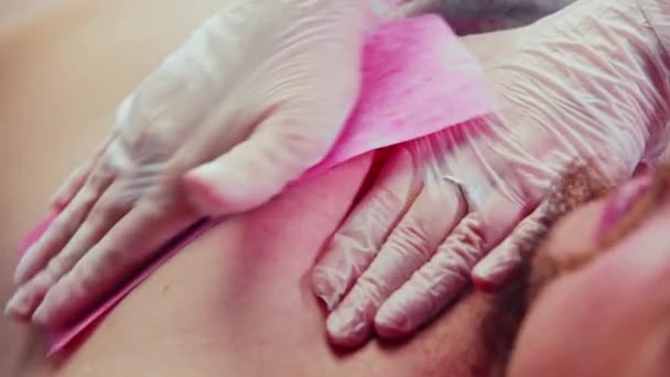 Wachsverfahren - der Meister entfernt die letzten Haare rund um die Brustwarze ihres männlichen Kunden — Stockvideo