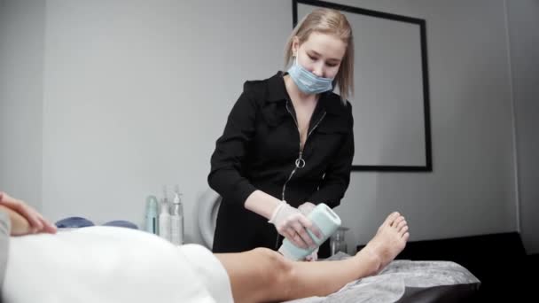 Blonde depilation master applying hot wax on the leg of her woman client — Stock Video