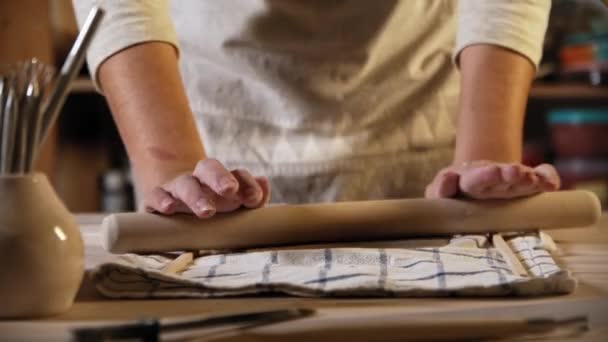 Young woman potter rolling out the clay using a rolling pin — Stok video