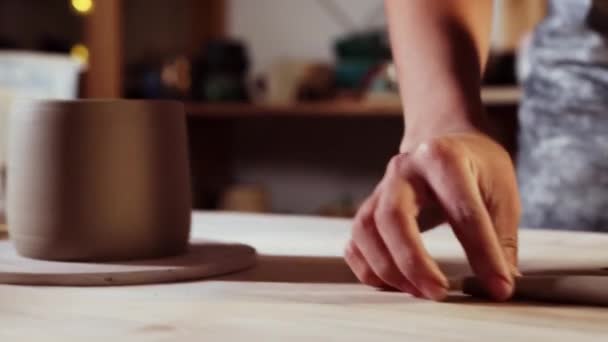 Pottery in the studio - young woman cuts off a small longer piece of clay — Stockvideo