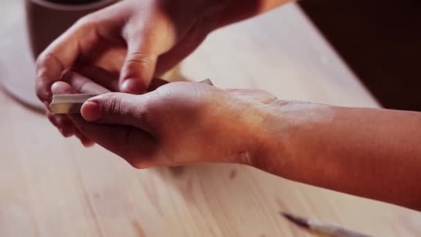 Cerámica en el estudio - mujer alfarera hace un pedazo más largo de arcilla en sus manos — Vídeo de stock