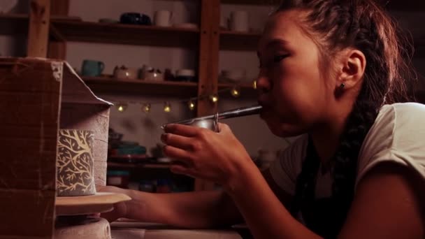 Pottery in the studio - woman potter manually sprays the paint by blowing into the device — 图库视频影像