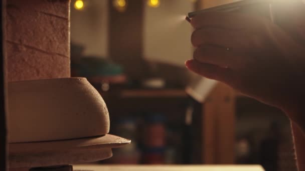 Pottery in the studio - potter manually sprays pink powder paint on the clay bowl — Stok video