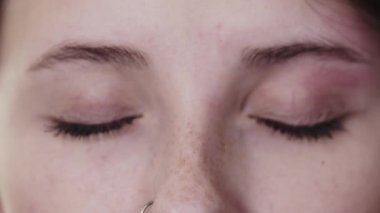 Gri yeşil gözlü güzel bir kadının kaşları arasındaki küçük kıllar.