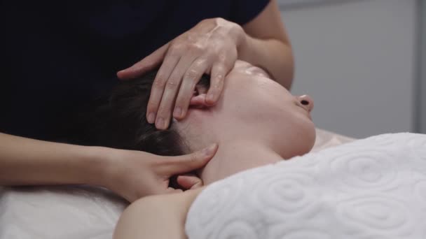 Massageassistentin massiert ihre Finger am Hals ihrer Kundin - massiert die wunden Stellen — Stockvideo