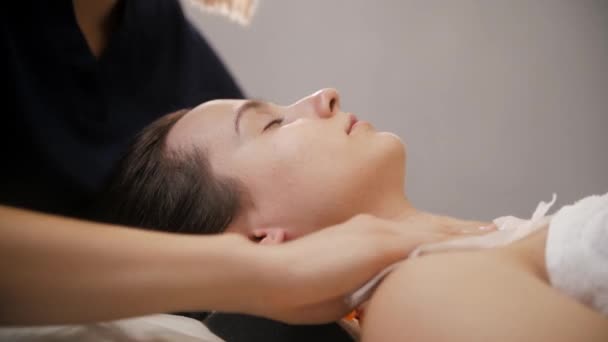 Massagem facial - o massagista esfregando o rosto de seu cliente feminino antes do procedimento — Vídeo de Stock