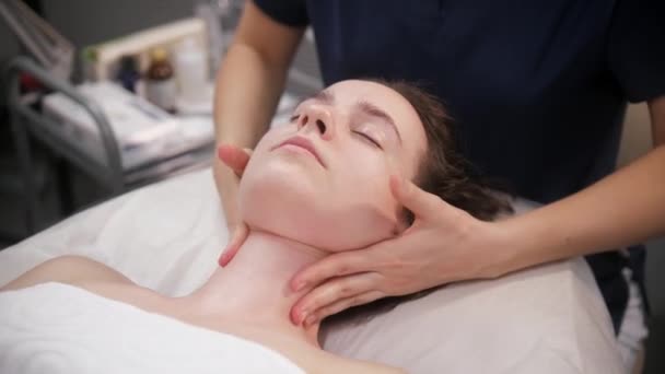 Sessão de massagem - a massagista relaxante pescoço de seu cliente feminino e aplicação de creme na pele — Vídeo de Stock