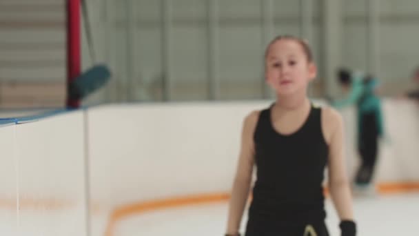 Menina patinadora figura patinando para a câmera e sorrindo — Vídeo de Stock