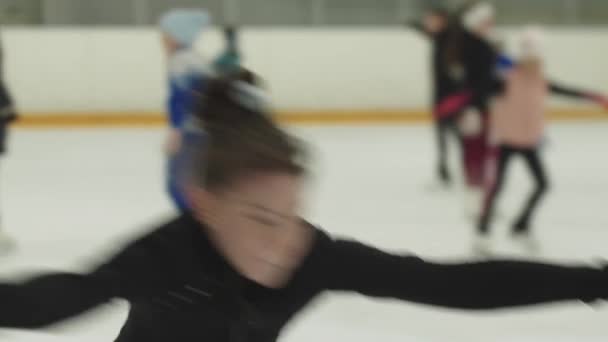 Menina em formação preta traje de patinação no gelo na pista pública — Vídeo de Stock